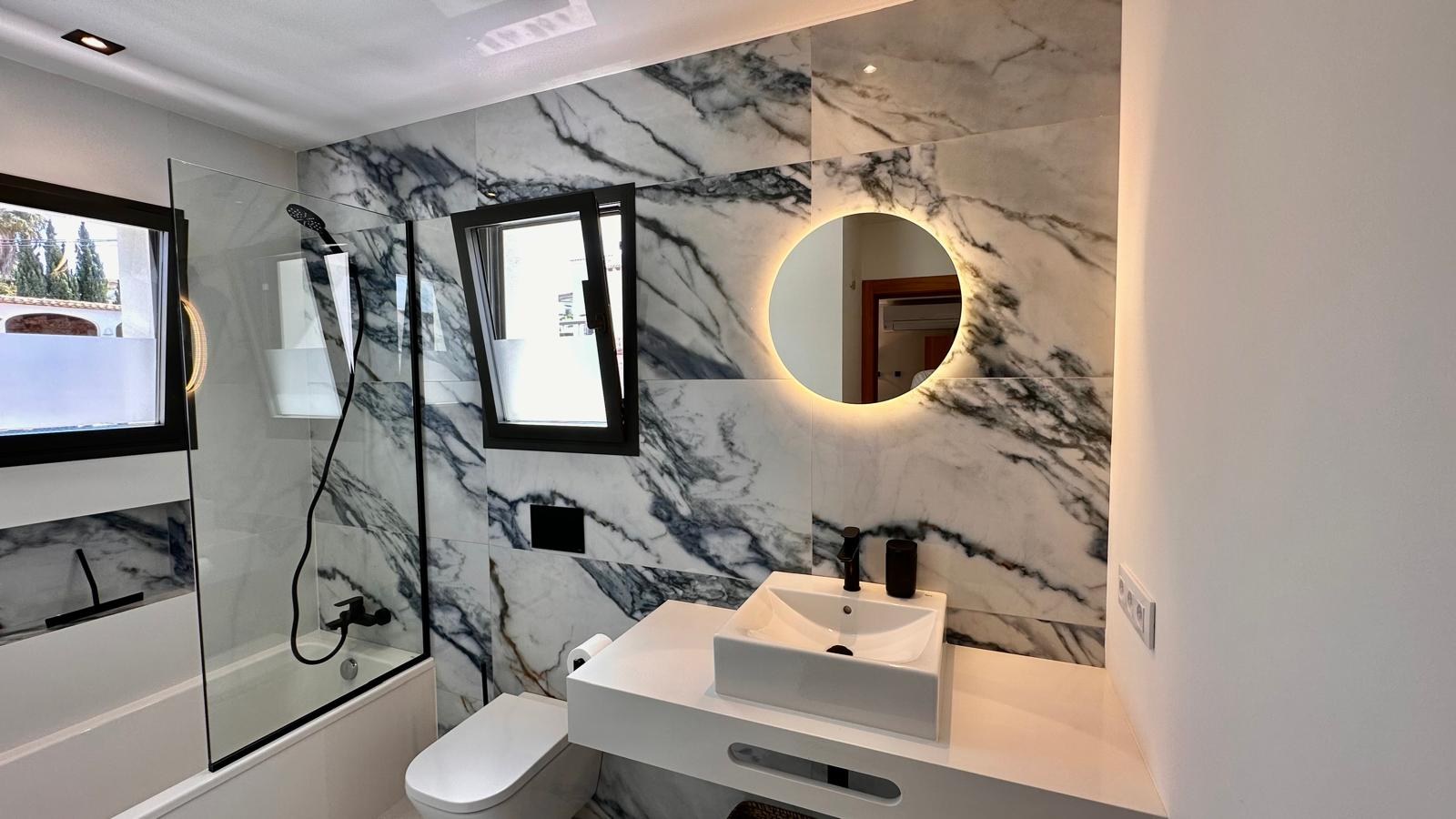 Badkamer van Villa Floris met marmer, ligbad en regendouche